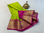 Green and pink saree with gold patterns on a white background