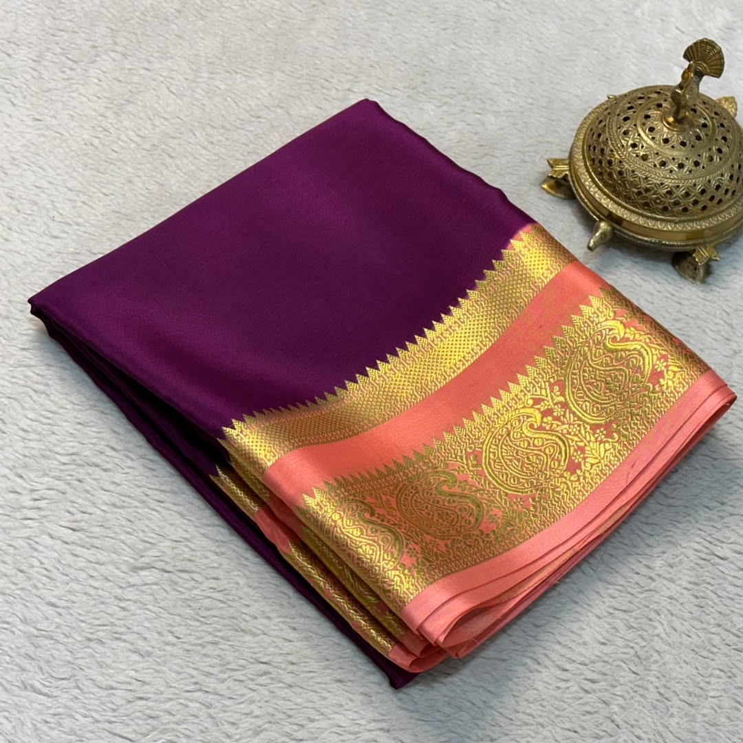 Purple saree with gold and pink border on a light gray background