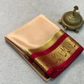 Beige saree with red and gold border on a gray background